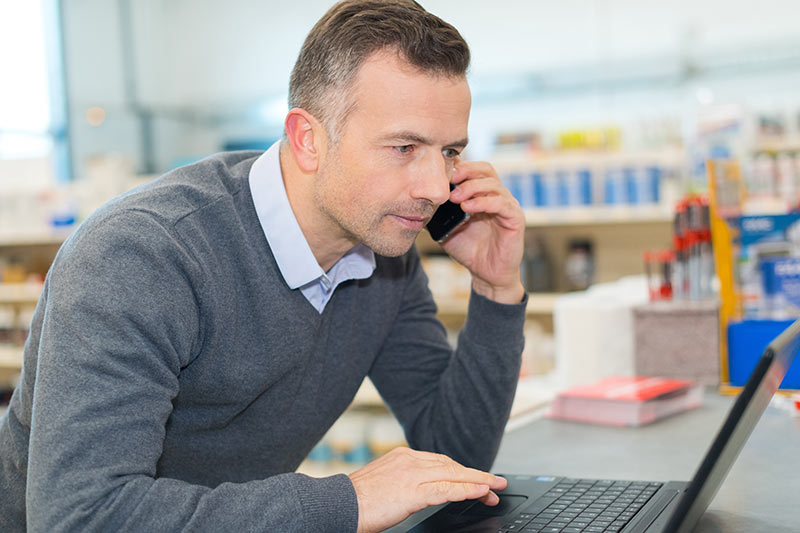 Mann am Telefon spricht über die Wartung von Werkzeugmaschinen